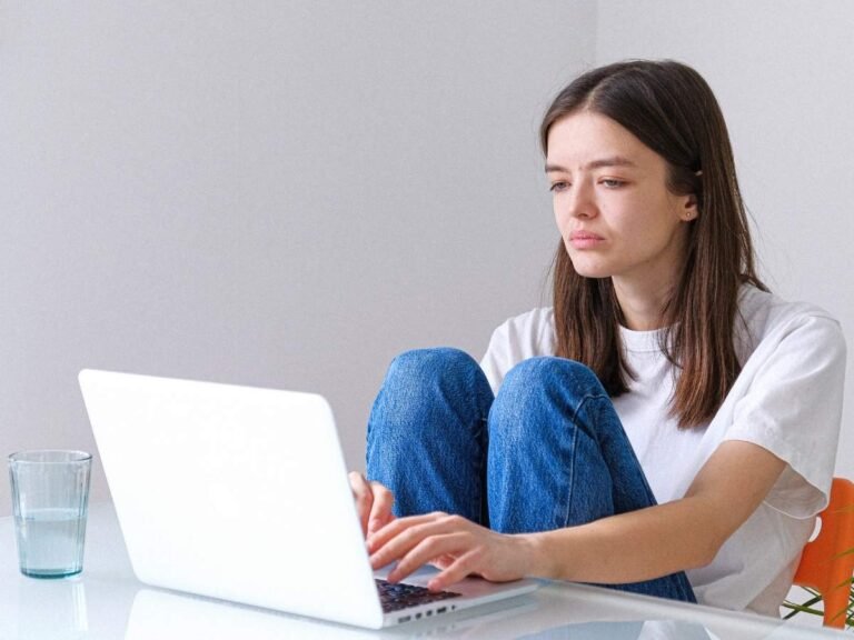 Person in Pakistan accessing online therapy on a smartphone at home, representing accessible mental health support