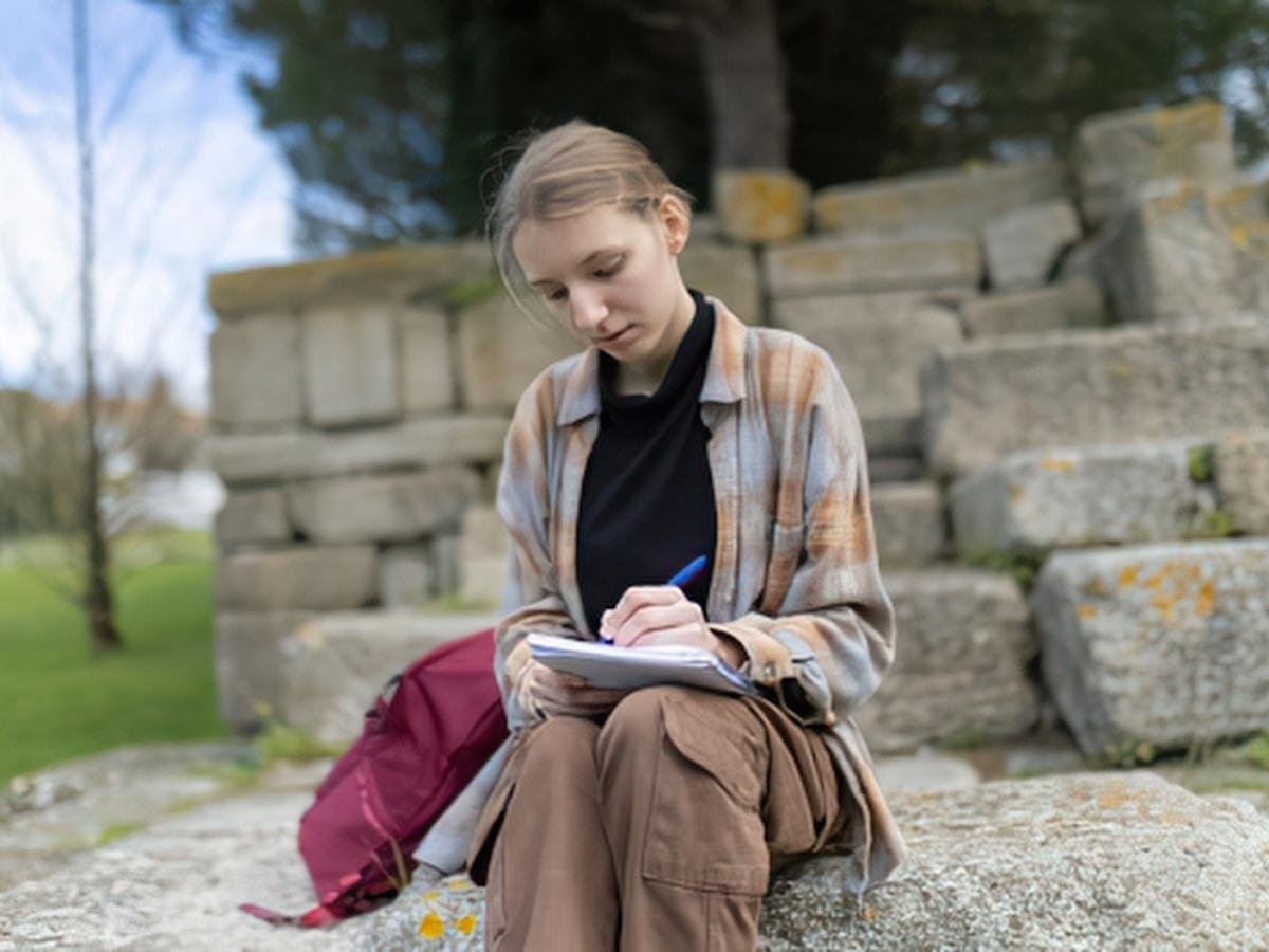 Person writing in a journal calmly, representing cognitive techniques for managing anxious thoughts.
