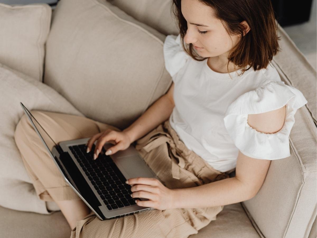 Person on a laptop in a comfortable home setting representing seeking professional support for burnout recovery.