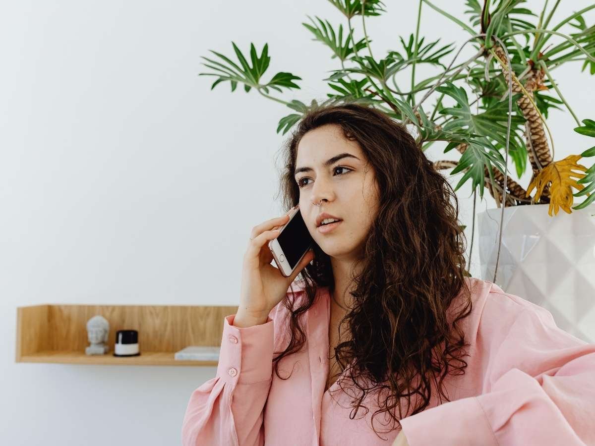 Person on a phone reaching out for support, representing the accessible steps anyone can take to address mental health stigma.
