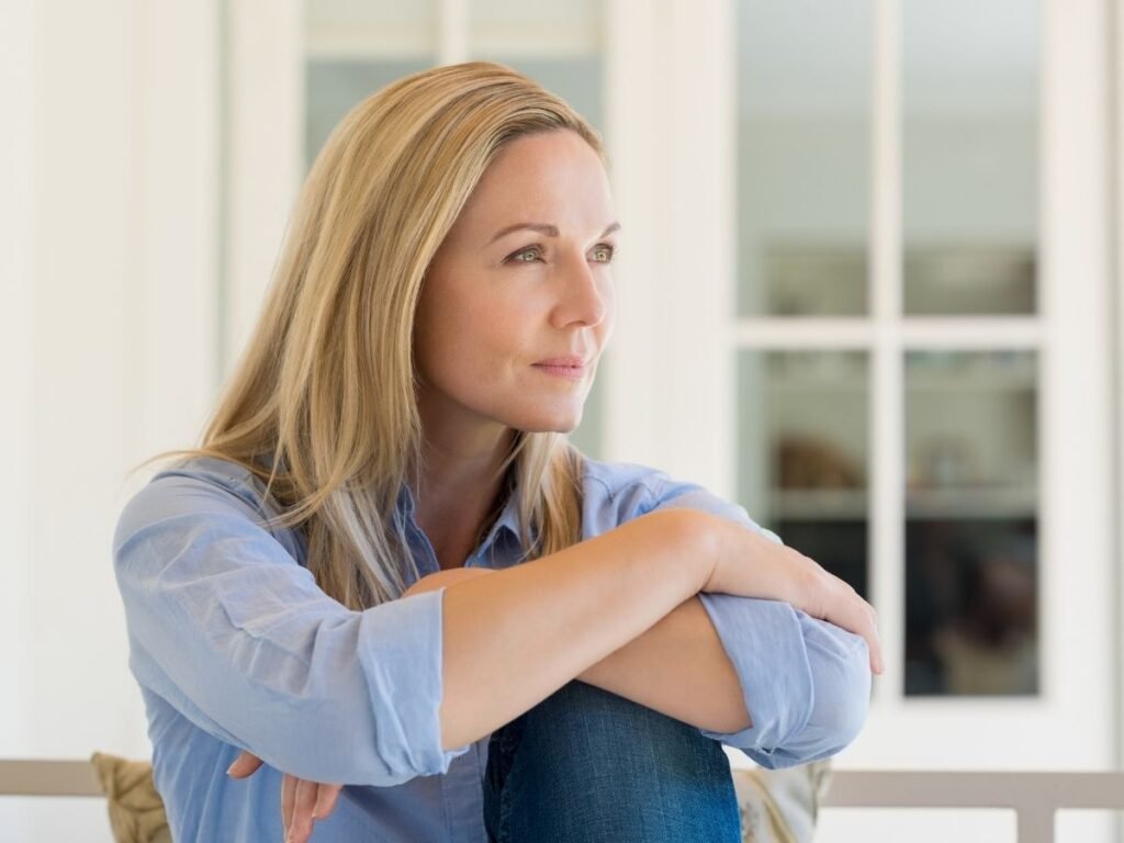 Person sitting thoughtfully reflecting on starting therapy, representing common misconceptions about mental health support