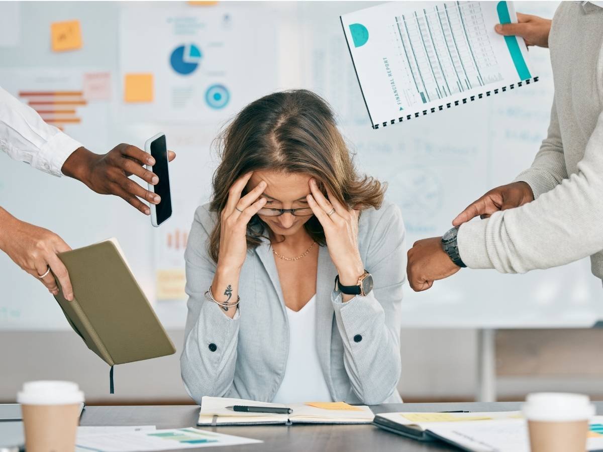 Person looking exhausted resting head on hands, representing chronic stress transitioning into anxiety.